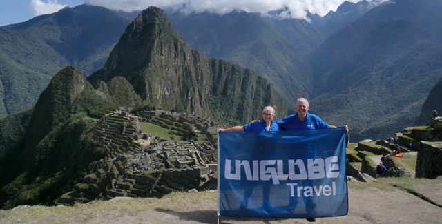 Amanda and Derek Holding UNIGLOBE Travel Banner at Machu Piccu